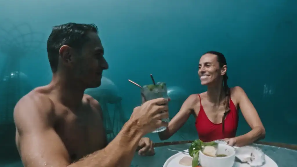 Man and woman enjoying an aperitif underwater at 1.5 Bar