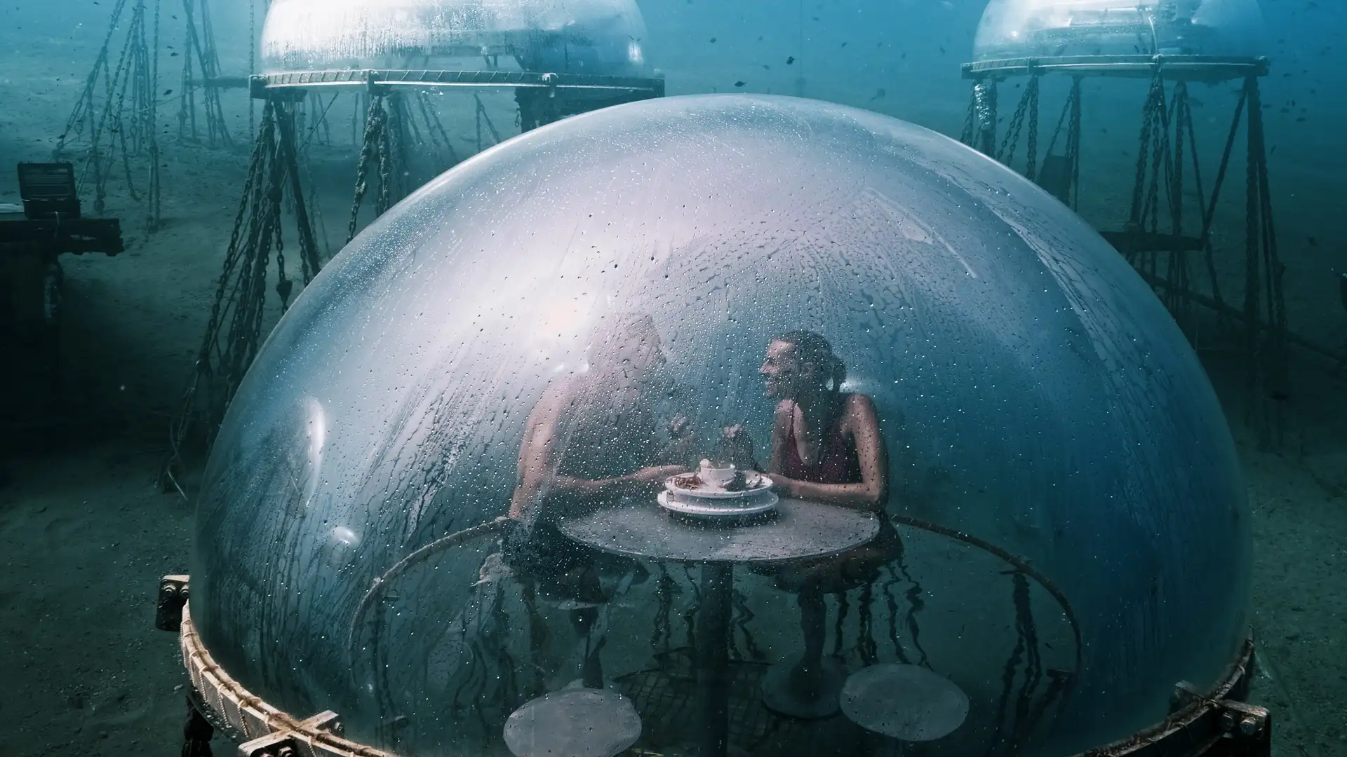 Man and woman enjoying an aperitif underwater at 1.5 Bar